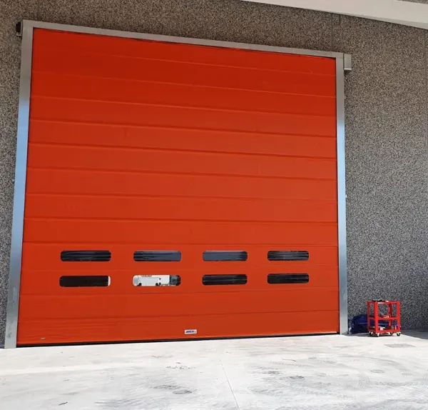 Porta rapida ad impacchettamento arancione installata su capannone in Emilia-Romagna